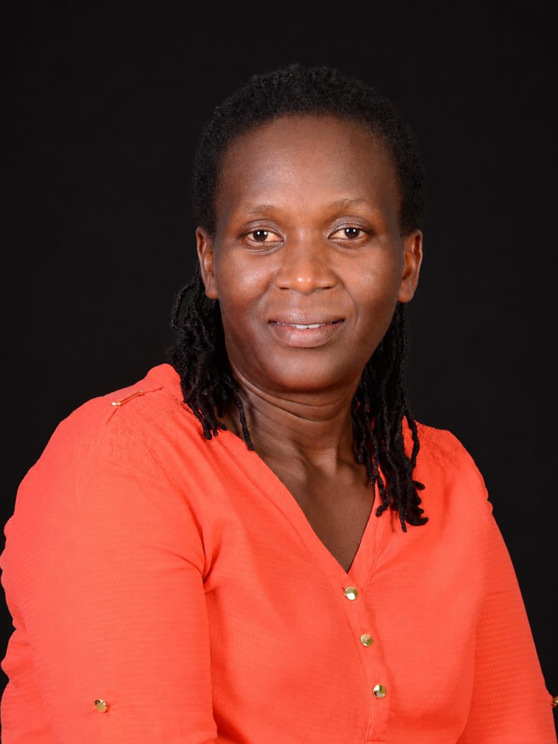 Violet Odhiambo, founder of Ability Bridge Learning Hub, wearing a coral blouse.